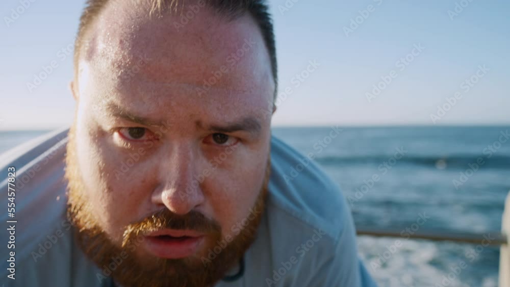 Fitness, tired man and breathing after running exercise, training or workout for recovery at the beach. Portrait of exhausted plus size male runner taking break to breath or recover from intense run Fitness, tired man and breathing after running exercise, training or workout for recovery at the beach. Portrait of exhausted plus size male runner taking break to breath or recover from intense run