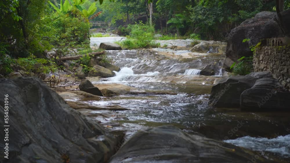 waterfall stream with rocks on nature clear motion flow water with green trees jungle in natural garden rainforest at Phalad Waterfall in Lan sang forest national park for summer landscape background