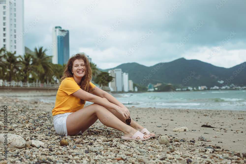 Portrait of happy positive red hair girl, young beautiful carefree woman enjoying summer vacation at sea, beach in exotic tropical country