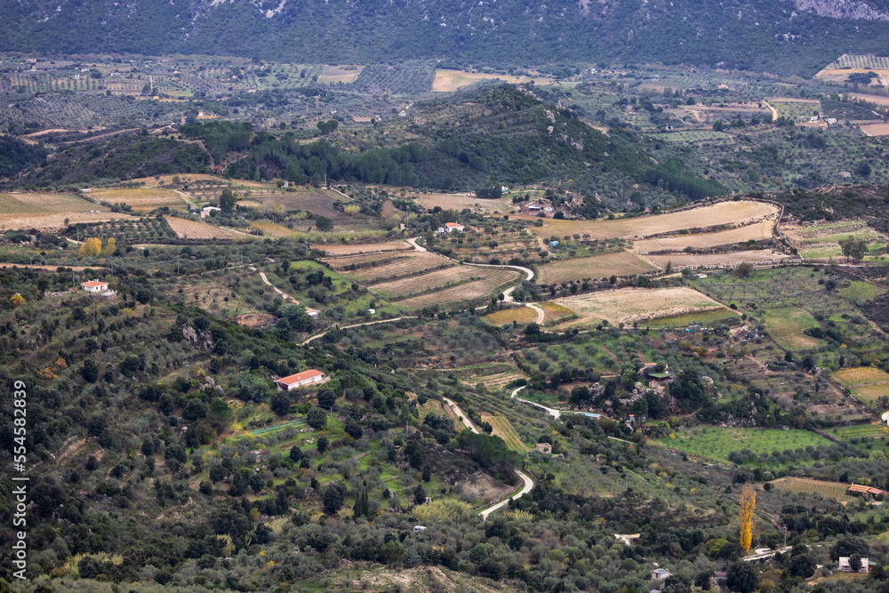 Farms and green fields with Mountain Landscape Background. Near Dorgali, Sardinia, Italy.