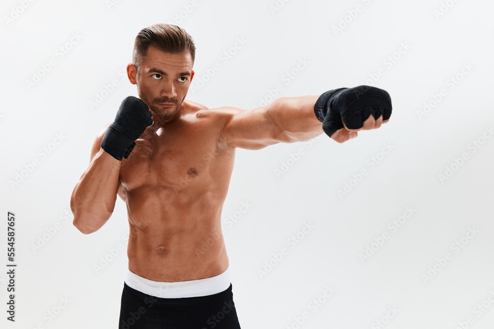 Man athletic bodybuilder poses in boxing gloves with nude torso abs in full-length background, boxing and martial arts. Advertising, sports, active lifestyle, competition, challenge concept. Man athletic bodybuilder poses in boxing gloves with nude torso abs in full-length background, boxing and martial arts. Advertising, sports, active lifestyle, competition, challenge concept.