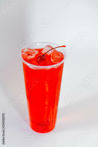 Cherry lemonade in a tall glass with ice and cherries