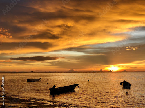 View of fishing boats with the sunset in the background