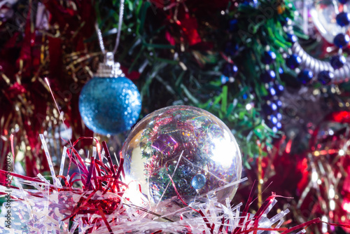 Close-up of Christmas decorations on a tree through lensball sphere