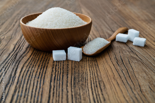 A bowl granulated sugar and sugar cubes on the table