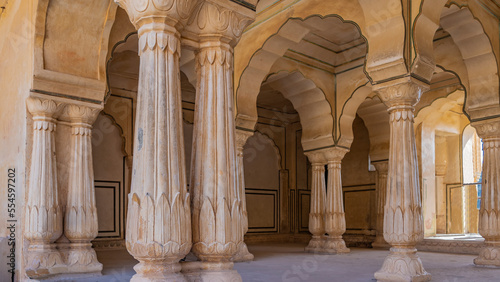 Architecture of the inner hall Amber Fort. High columns with elegant carvings and decorative capitals, beautiful arched vaults are made of orange sandstone. India. Jaipur