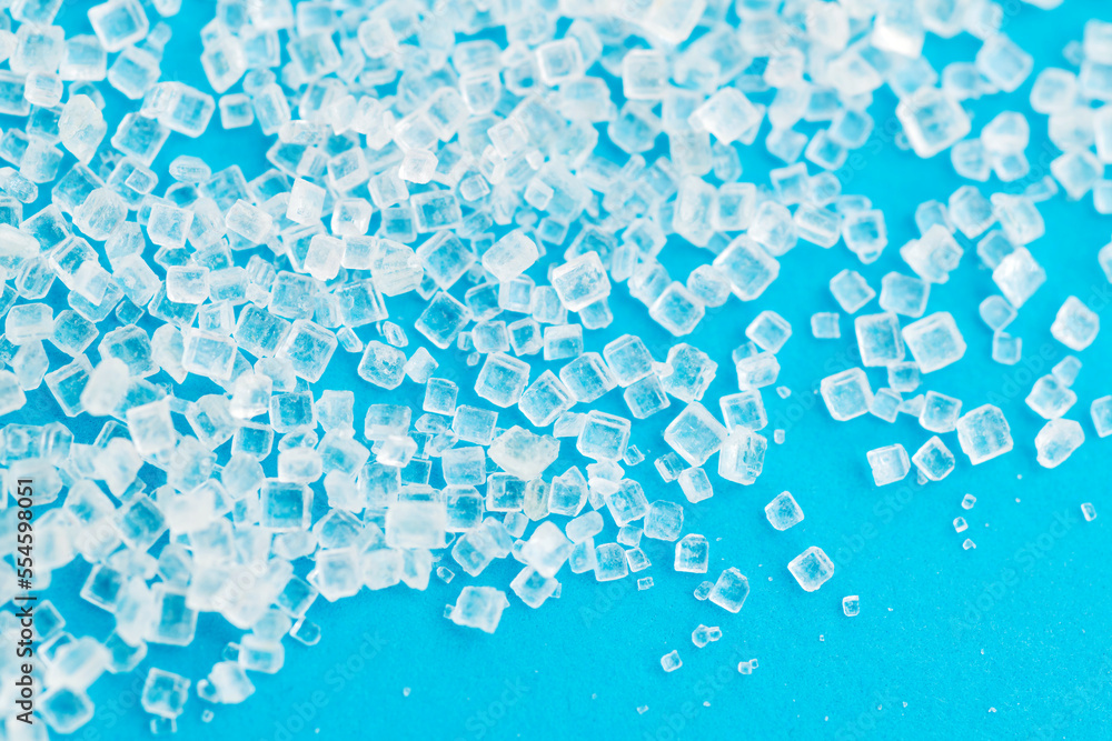 White sugar crystals on blue background White sugar crystals on blue background