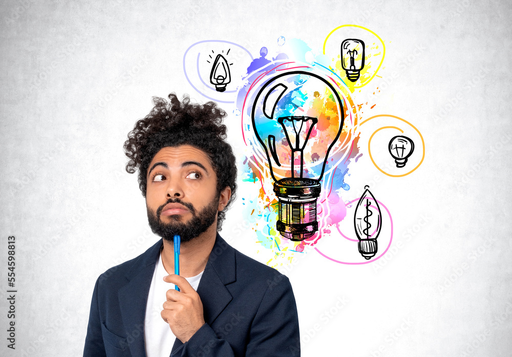 Pensive middle eastern businessman and colorful lightbulbs on grey concrete wall Pensive middle eastern businessman and colorful lightbulbs on grey concrete wall