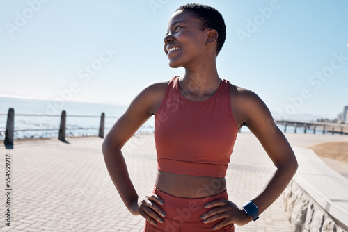 Happy, fitness and black woman on the promenade for running, cardio exercise and idea for sports in Australia. Vision, smile and African runner training for a marathon, race or health by the ocean