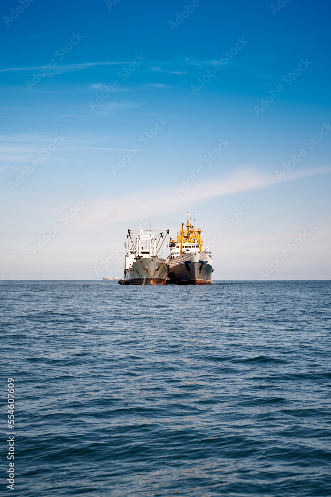 FIshing boat in the Pacific ocean. Against snow covered volcanos. Kamchatka FIshing boat in the Pacific ocean. Against snow covered volcanos. Kamchatka
