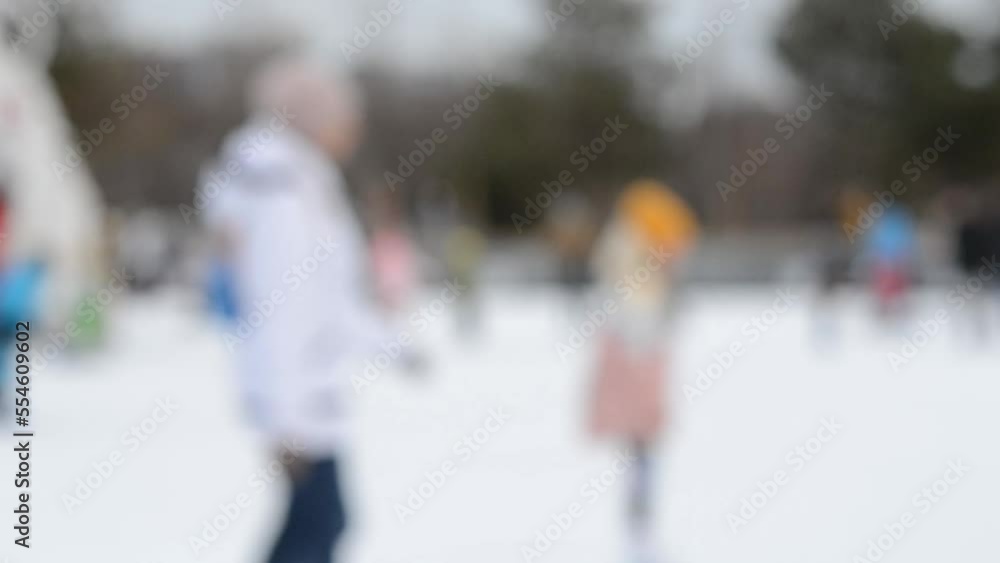 People skating on an ice skating rink on a winter day. Blurred background. Leisure entertainment vacation weekend holidays winter activities lifestyle. Public city winter fun ecreation enjoying. People skating on an ice skating rink on a winter day. Blurred background. Leisure entertainment vacation weekend holidays winter activities lifestyle. Public city winter fun ecreation enjoying.