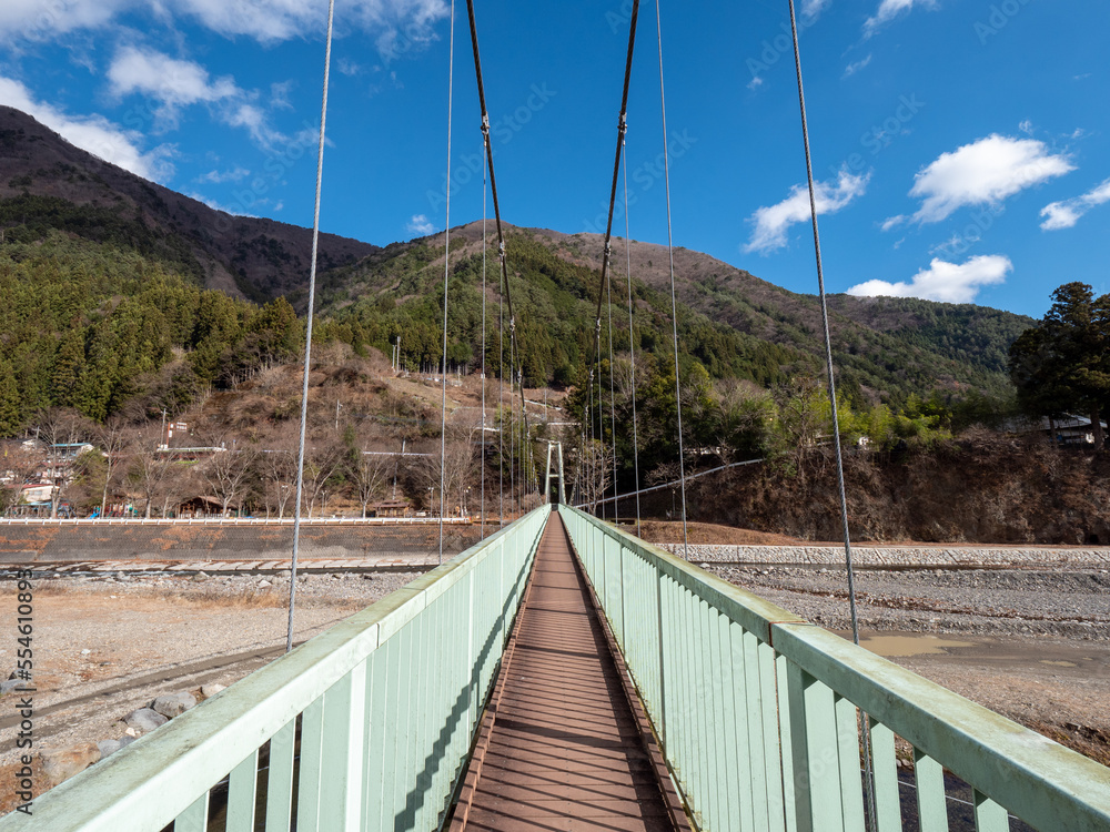 Obraz premium 冬晴れの山梨県丹波山村の丹波川にかかるやまびこ橋