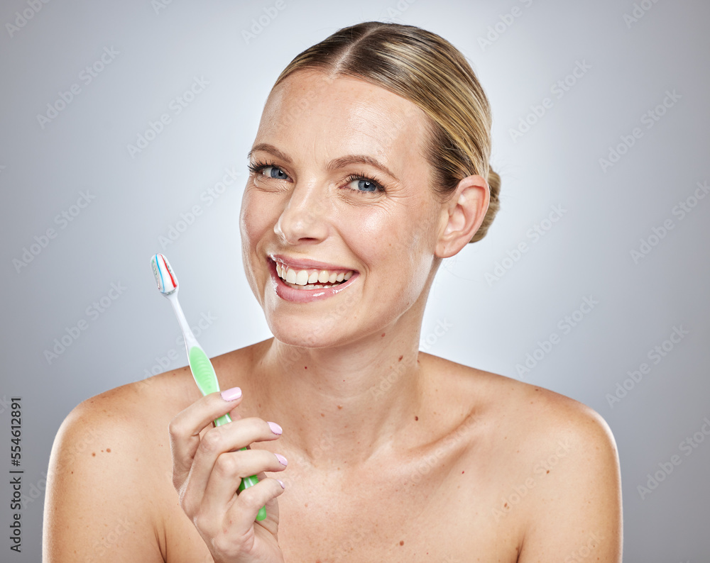 Obraz premium Face, teeth and woman with toothbrush in studio isolated on a gray background. Oral health, dental veneers and female model getting ready to brush with toothpaste for hygiene, cleaning and wellness.