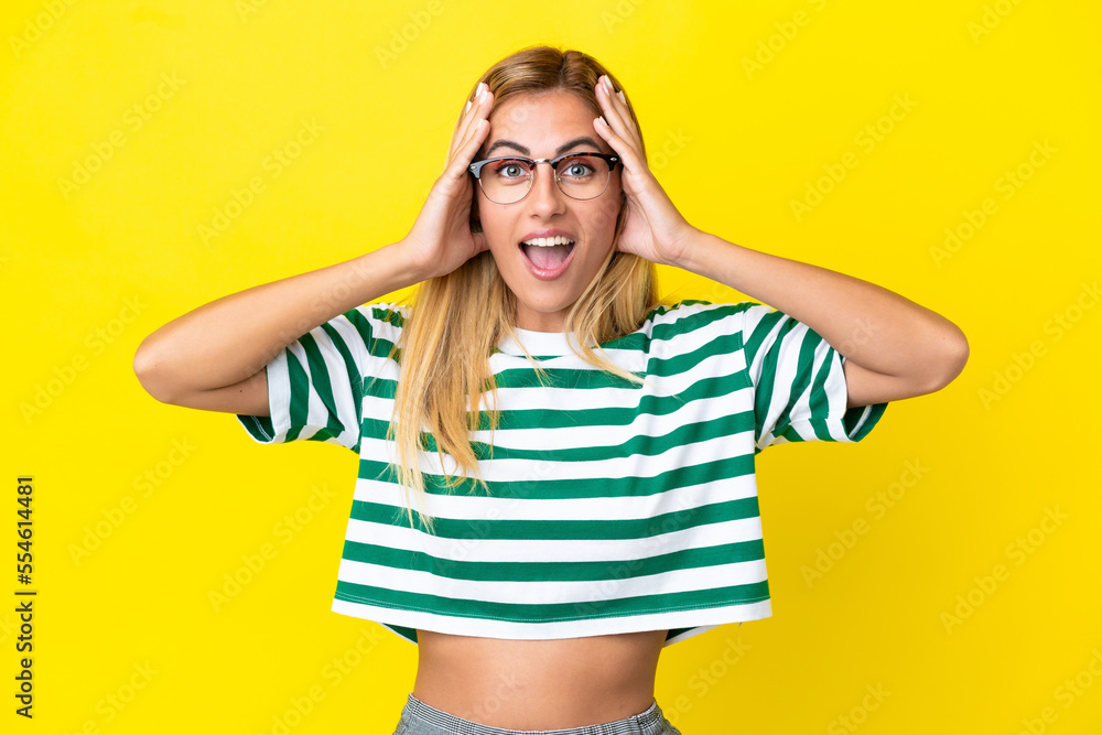 Blonde Uruguayan girl isolated on yellow background with surprise expression Blonde Uruguayan girl isolated on yellow background with surprise expression