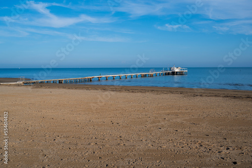 Sandy beach and restaurant on stilts at sea