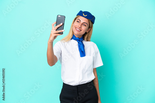 Airplane stewardess Uruguayan woman isolated on blue background making a selfie