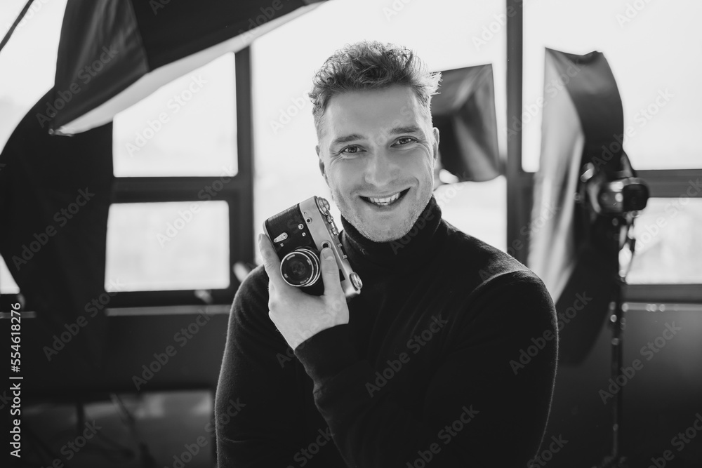Man looking through the viewfinder of the lefthanded camera lens is