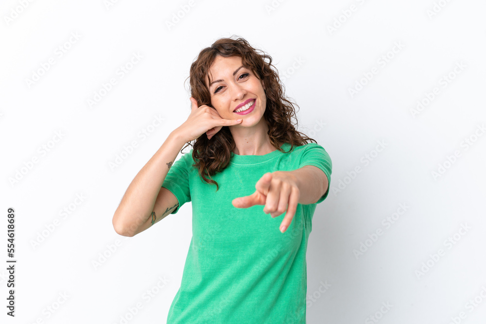 Young woman with curly hair isolated on white background making phone gesture and pointing front Young woman with curly hair isolated on white background making phone gesture and pointing front