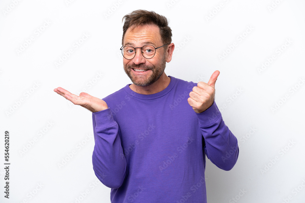 Fototapeta premium Middle age caucasian man isolated on white background holding copyspace imaginary on the palm to insert an ad and with thumbs up
