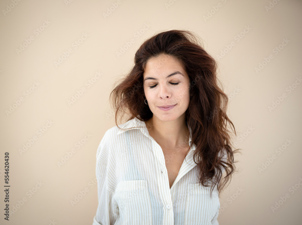 beautiful young woman with long hair posing in front of brown background wearing striped shirt beautiful young woman with long hair posing in front of brown background wearing striped shirt