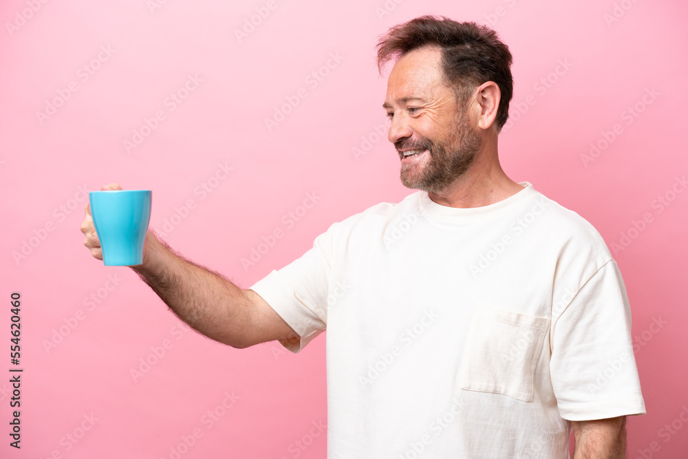 Middle age caucasian man holding cup of coffee isolated on pink background with happy expression Middle age caucasian man holding cup of coffee isolated on pink background with happy expression