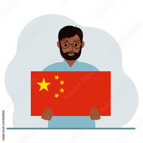 A man holds a Chinese flag. The concept of demonstration, national holiday or patriotism. Nationality.
