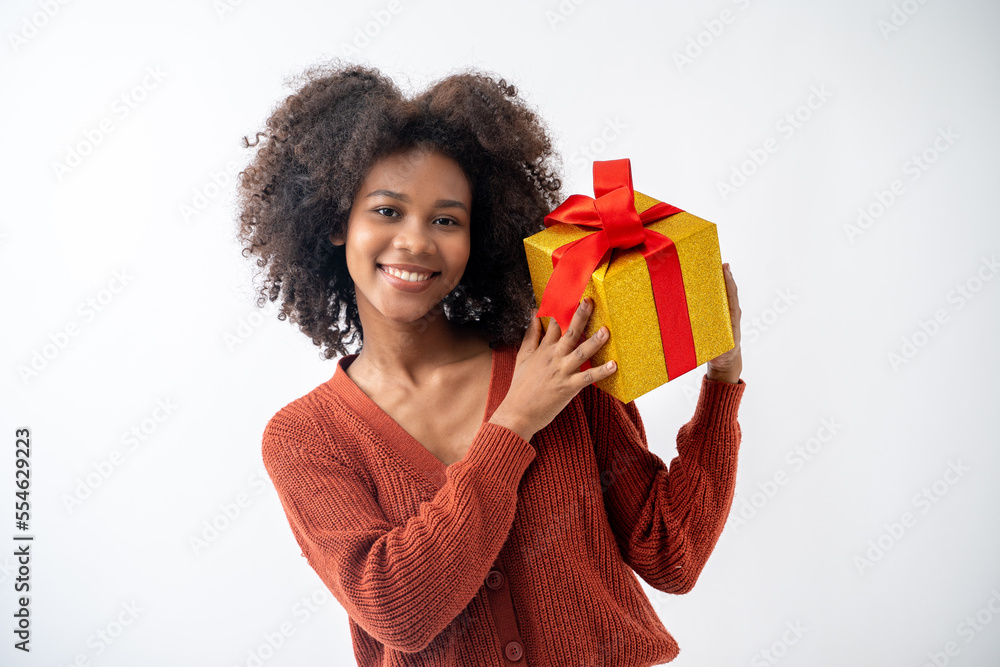 Portrait of young attractive african american woman with curly hair presenting gift box in studio on white background. Portrait of young attractive african american woman with curly hair presenting gift box in studio on white background.