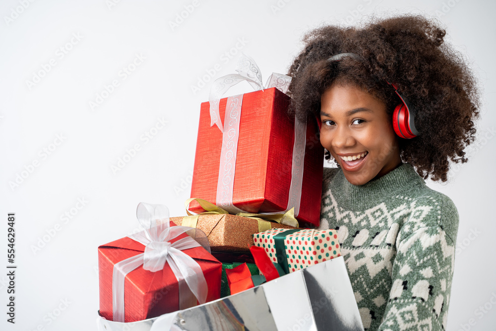 Portrait of young attractive african american woman with curly hair and headphone holding many gifts in studio on white background. Portrait of young attractive african american woman with curly hair and headphone holding many gifts in studio on white background.