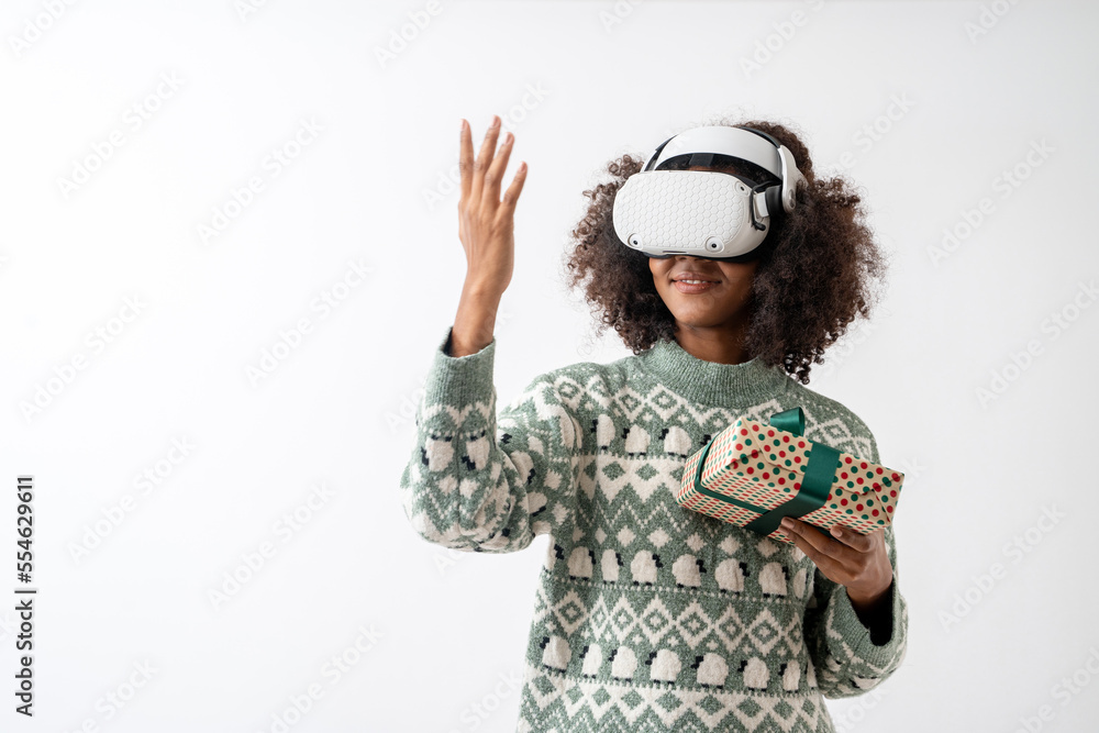 Portrait of young attractive african american woman curly hair with VR goggles holding gift box in studio on white background. Portrait of young attractive african american woman curly hair with VR goggles holding gift box in studio on white background.