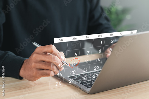 Businessman manages time for effective work. Calendar on the virtual screen interface. Highlight appointment reminders and meeting agenda on the calendar. Time management concept.