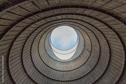 Inside a cooling tower of a nuclear power plant. View upwards, blue sky. abandoned place