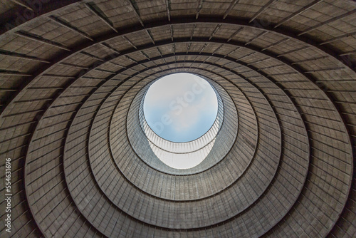 Inside a cooling tower of a nuclear power plant. View upwards  blue sky. abandoned place