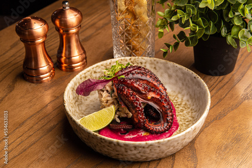 Octopus with rice, beetroot sauce and lime