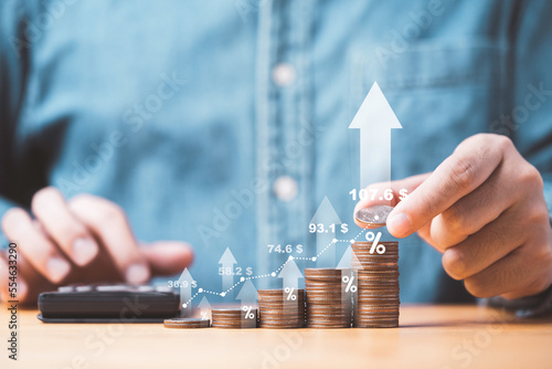 Businessman stacking money coins with up arrow and percentage symbol for financial banking increase interest rate or mortgage investment dividend from business growth concept.