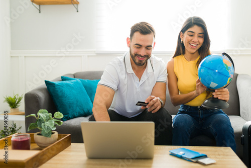 Excited couple booking a vacation trip online