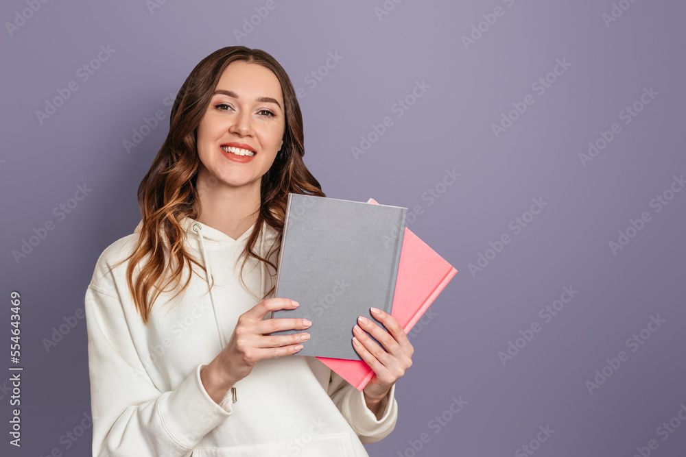 Ukrainian student girl smiles and holds books on a dark gray background copy space Ukrainian student girl smiles and holds books on a dark gray background copy space