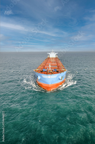 Impressive aerial wide angle view of a giant cargo ship carrying ores crossing the oceans