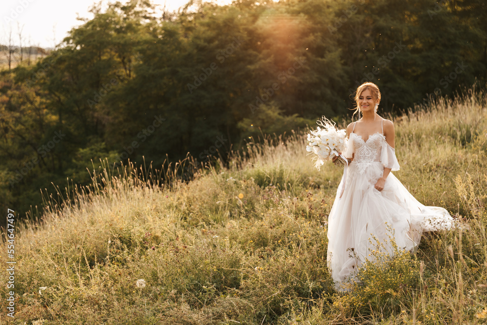 A beautiful bride in a wedding dress goes to the groom against the backdrop of a beautiful sunset A beautiful bride in a wedding dress goes to the groom against the backdrop of a beautiful sunset