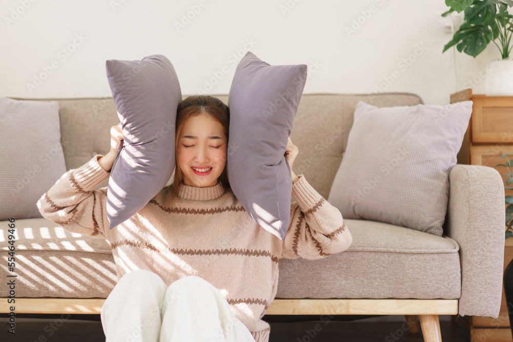 Rest time concept, Women stressful and sad while sitting on the floor and closing ears with pillow Rest time concept, Women stressful and sad while sitting on the floor and closing ears with pillow
