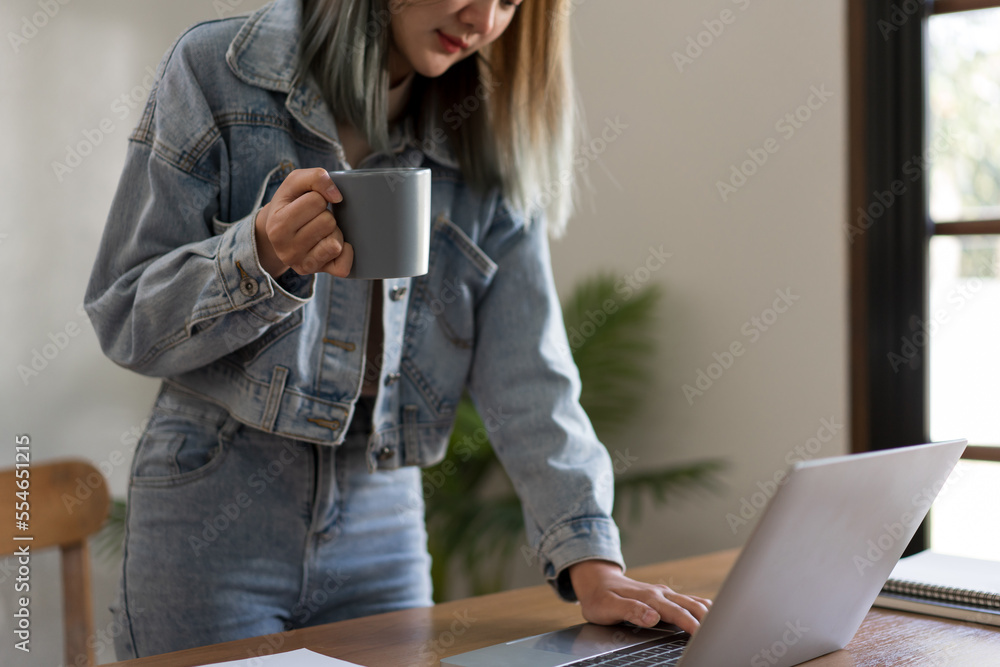 Fototapeta premium Creative design concept, Female designer drinking coffee while working on laptop to contact client