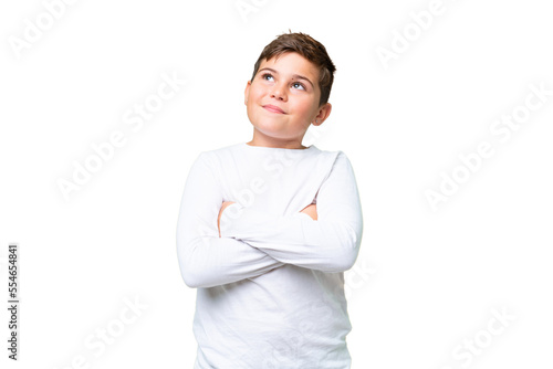 Little caucasian kid over isolated chroma key background looking up while smiling
