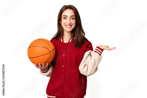 Young basketball player woman over isolated chroma key background extending hands to the side for inviting to come © luismolinero