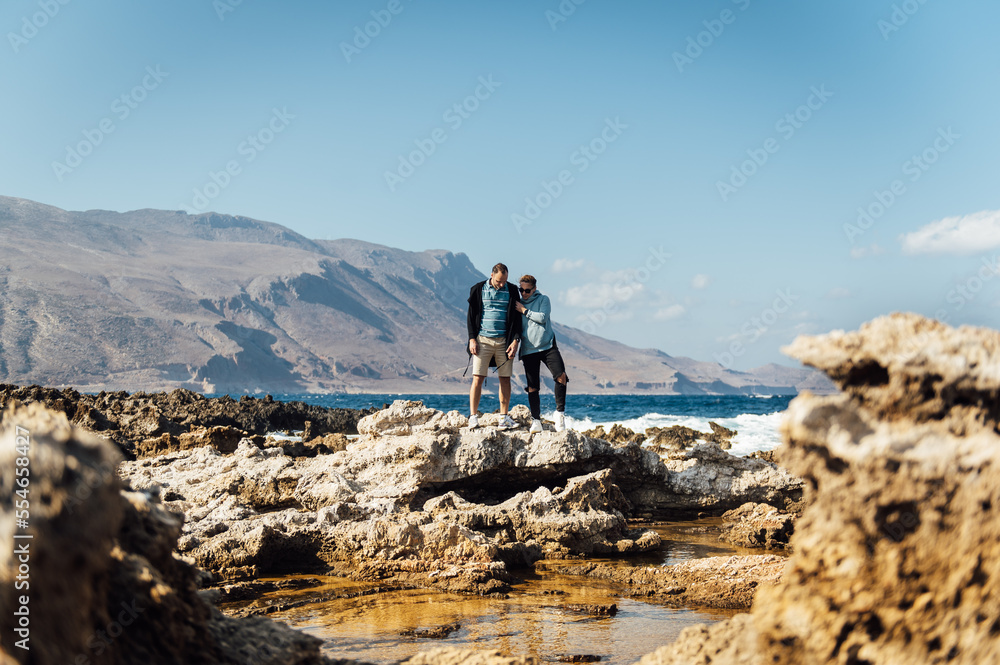 Happy couple walking and hugging on the shores of the mediterranean sea
