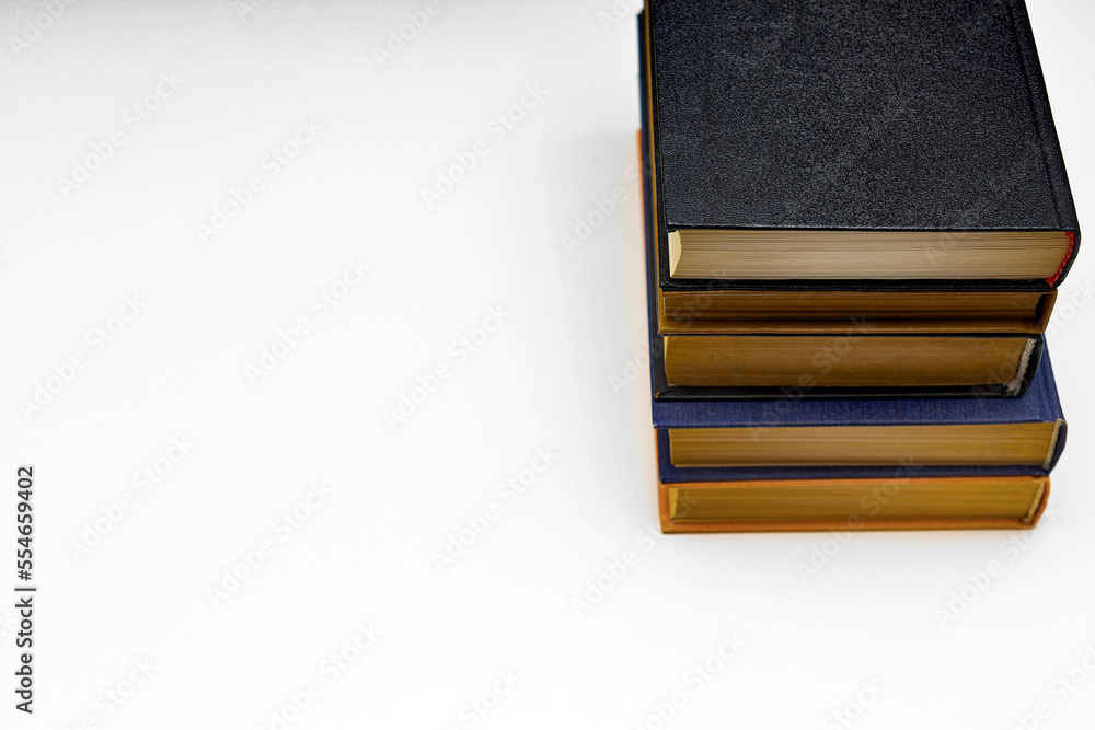 A stack of old books lies on the table.