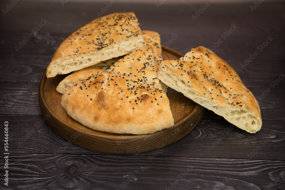 Armenian lavash, on a white wooden background, wooden plate Armenian lavash, on a white wooden background, wooden plate
