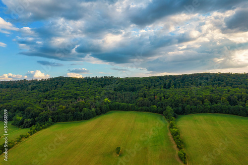 Flying over some golden fields and green forests. Germany.