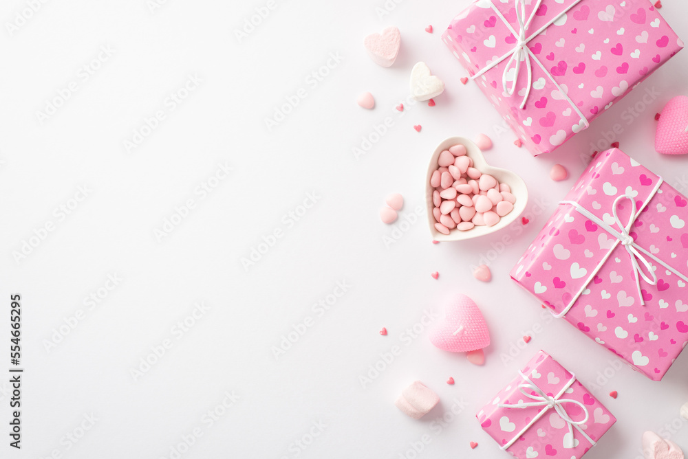 Valentine's Day concept. Top view photo of pink gift boxes heart shaped saucer with sprinkles marshmallow and candles on isolated white background with copyspace Valentine's Day concept. Top view photo of pink gift boxes heart shaped saucer with sprinkles marshmallow and candles on isolated white background with copyspace