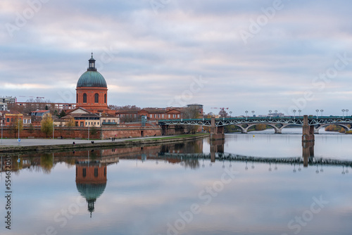 Scenic cityscape view on the dome of St Joseph de la Grave chapel and St Peter bridge with reflection in Garonne river, Toulouse, France