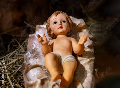 Fototapeta Newborn Jesus Christ figurine lying. Baby boy toy, holy figure
