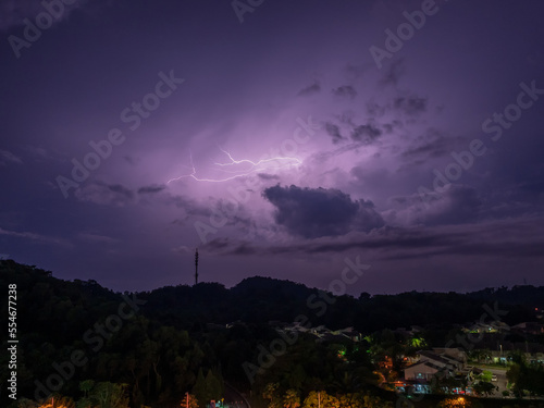 Lightning strikes during thunder storm over a hill view during night